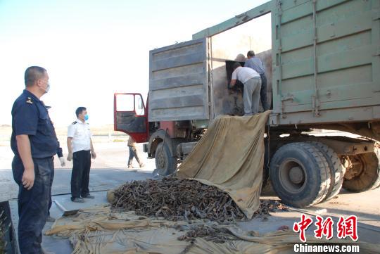 圖為現(xiàn)場關(guān)員監(jiān)督犯罪嫌疑人卸去走私物品。　呼和浩特海關(guān)提供　攝