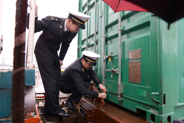 圖為：海關關員冒雨首趟班列集裝箱施加海關關鎖 何劍涯/攝